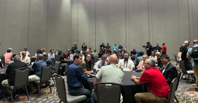 groups of people sitting at roundtables at Commercial UAV Expo having a discussion